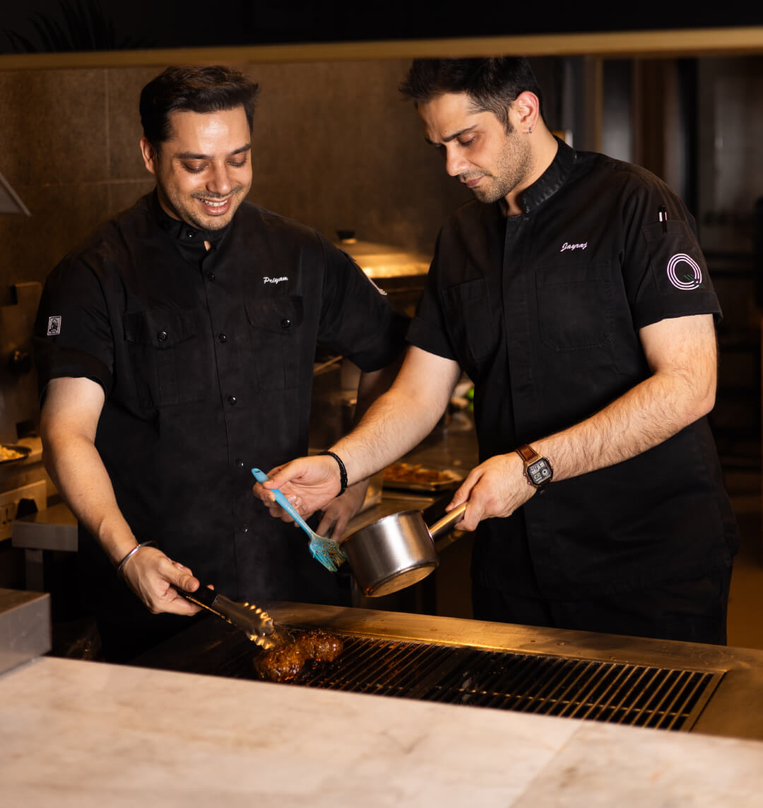 Chef preparing gourmet dishes at The Q by The Quorum Club, showcasing curated culinary offerings for exclusive events.